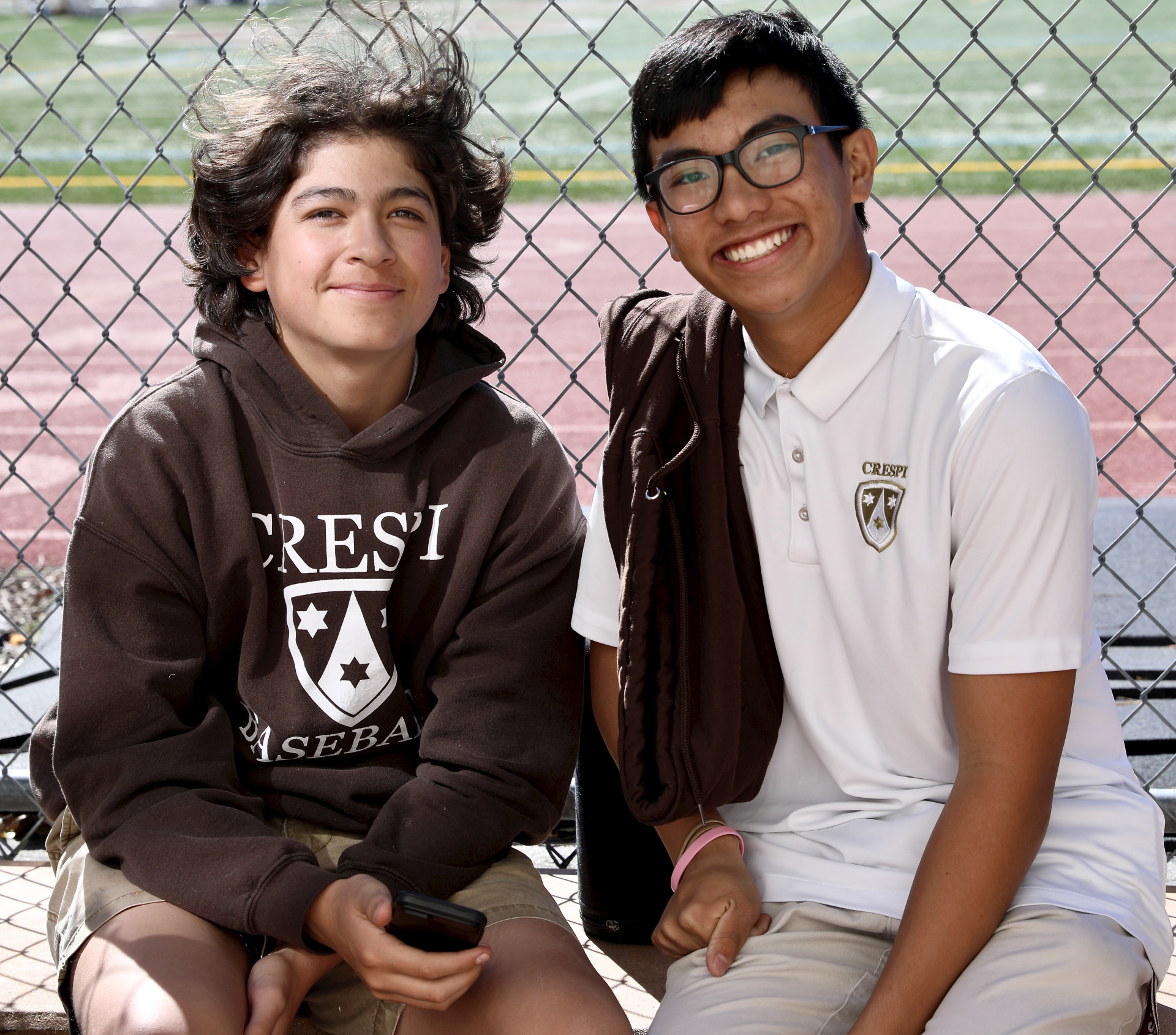 2 boys against chain link fence