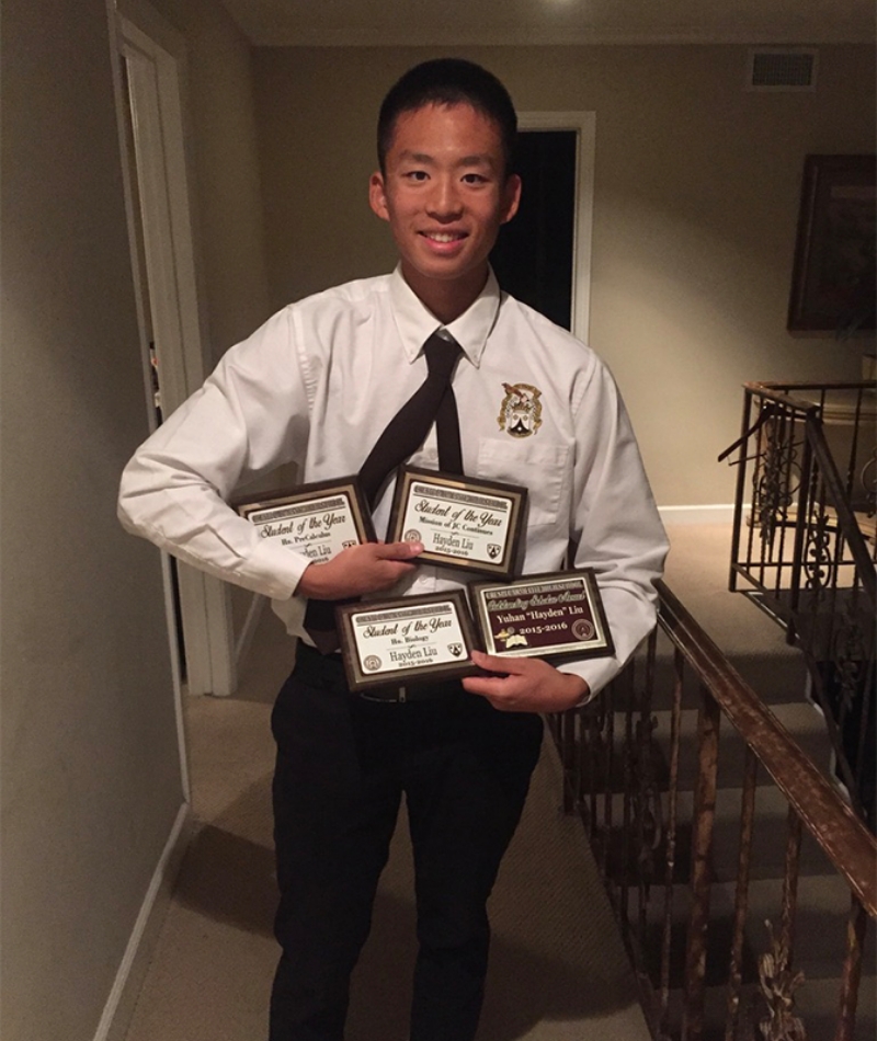 international student holding awards